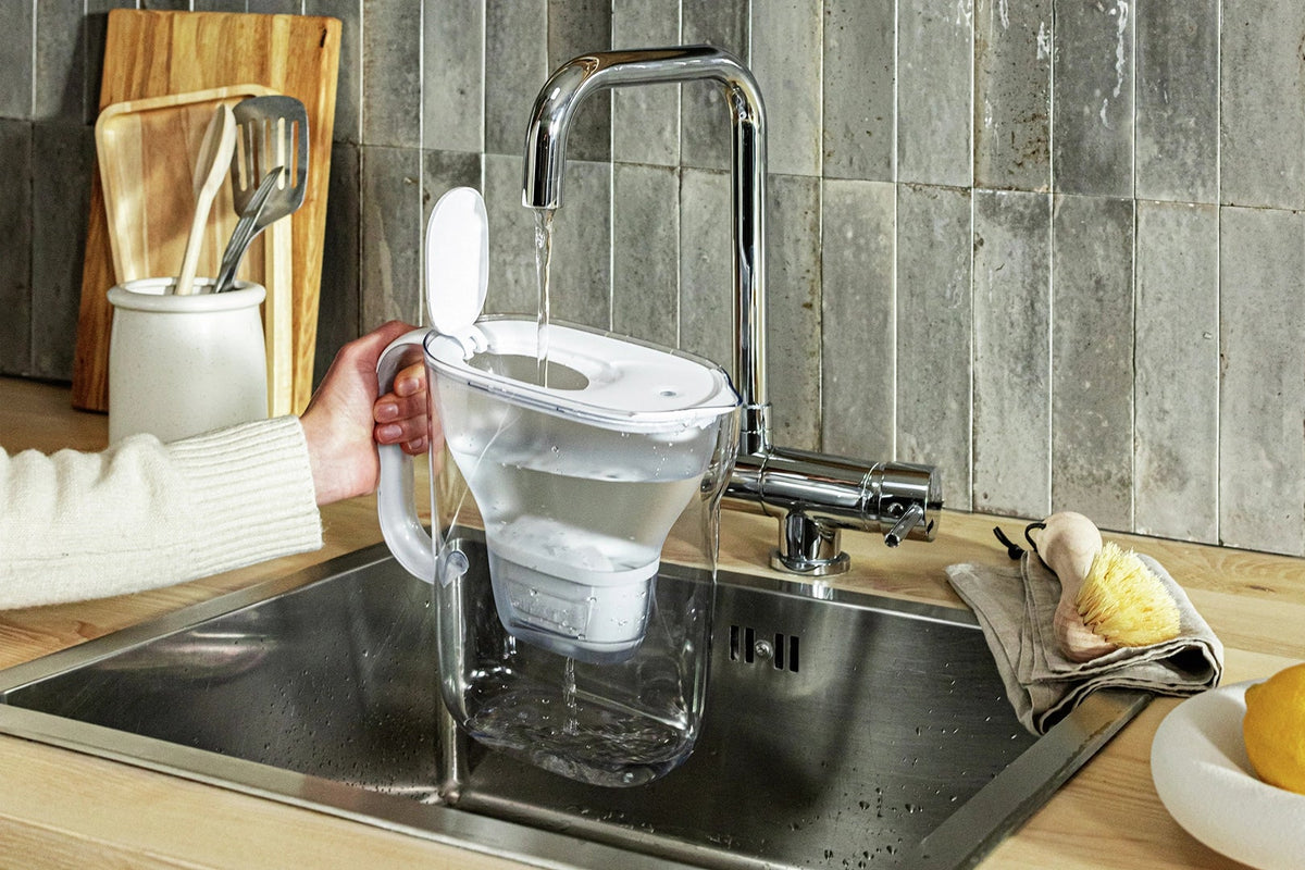 Person filling water in white water filter jug BRITA Style Essential.