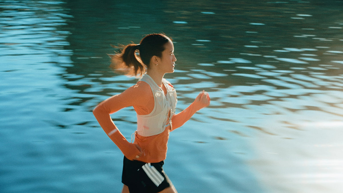 Woman running by a riverside.